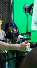 Film students working with camera in front of a green screen