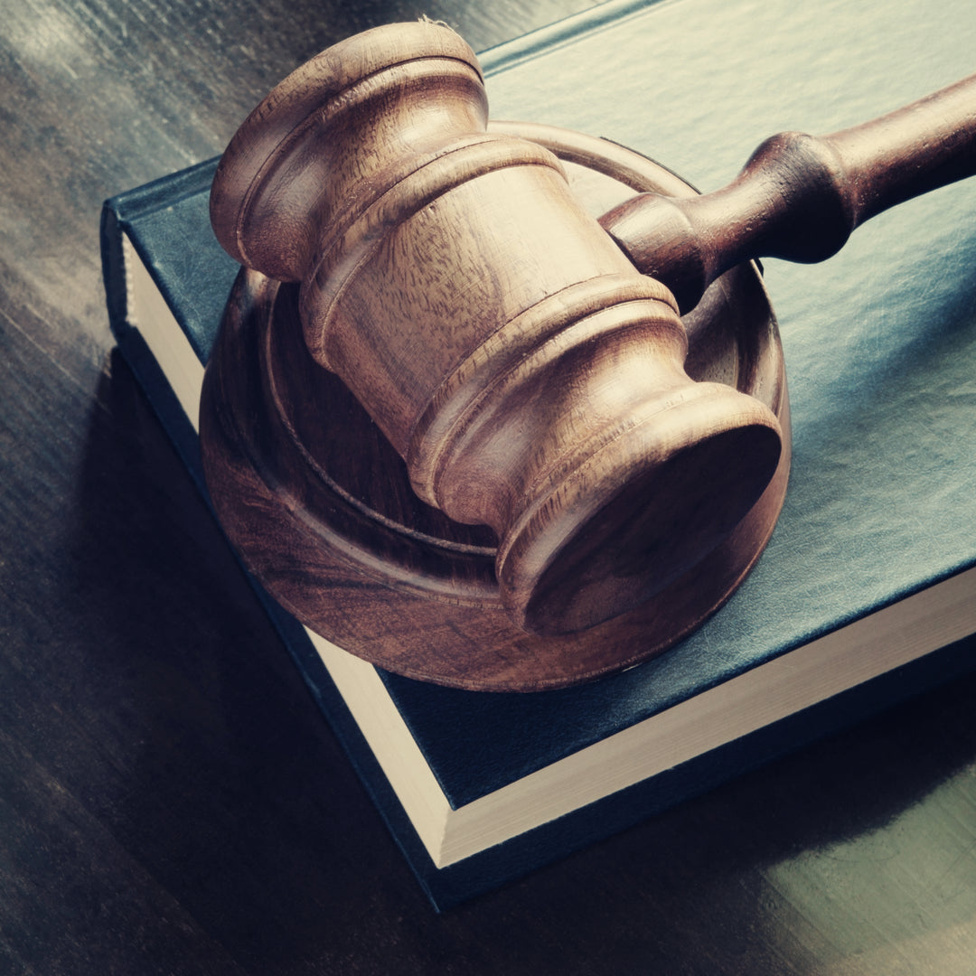a gavel, wooden block and book piled on a table