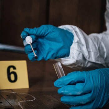 A forensic scientist in blue gloves holding a test tube and swab and a 