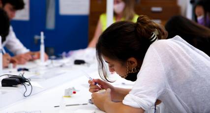 Dental student doing practical work with other students in a classroom