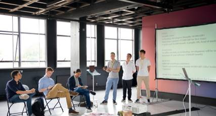 A group of students standing in front of a projector presenting their work