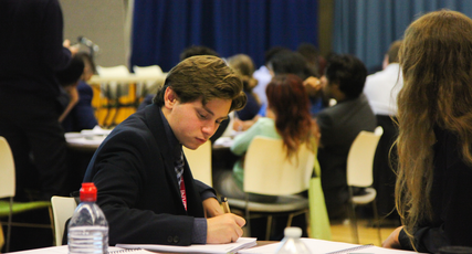 Politics student posting paper into a ballot box