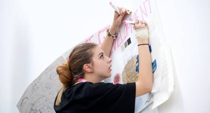 A student fashion designer drawing ideas on a poster