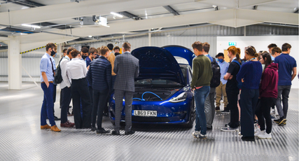 Engineering students stood around a car with its bonnet up